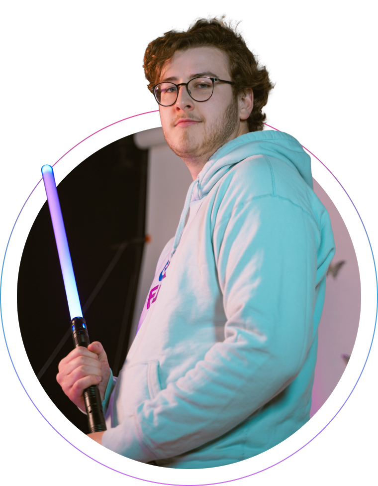 Liam holds a purple plastic light saber.