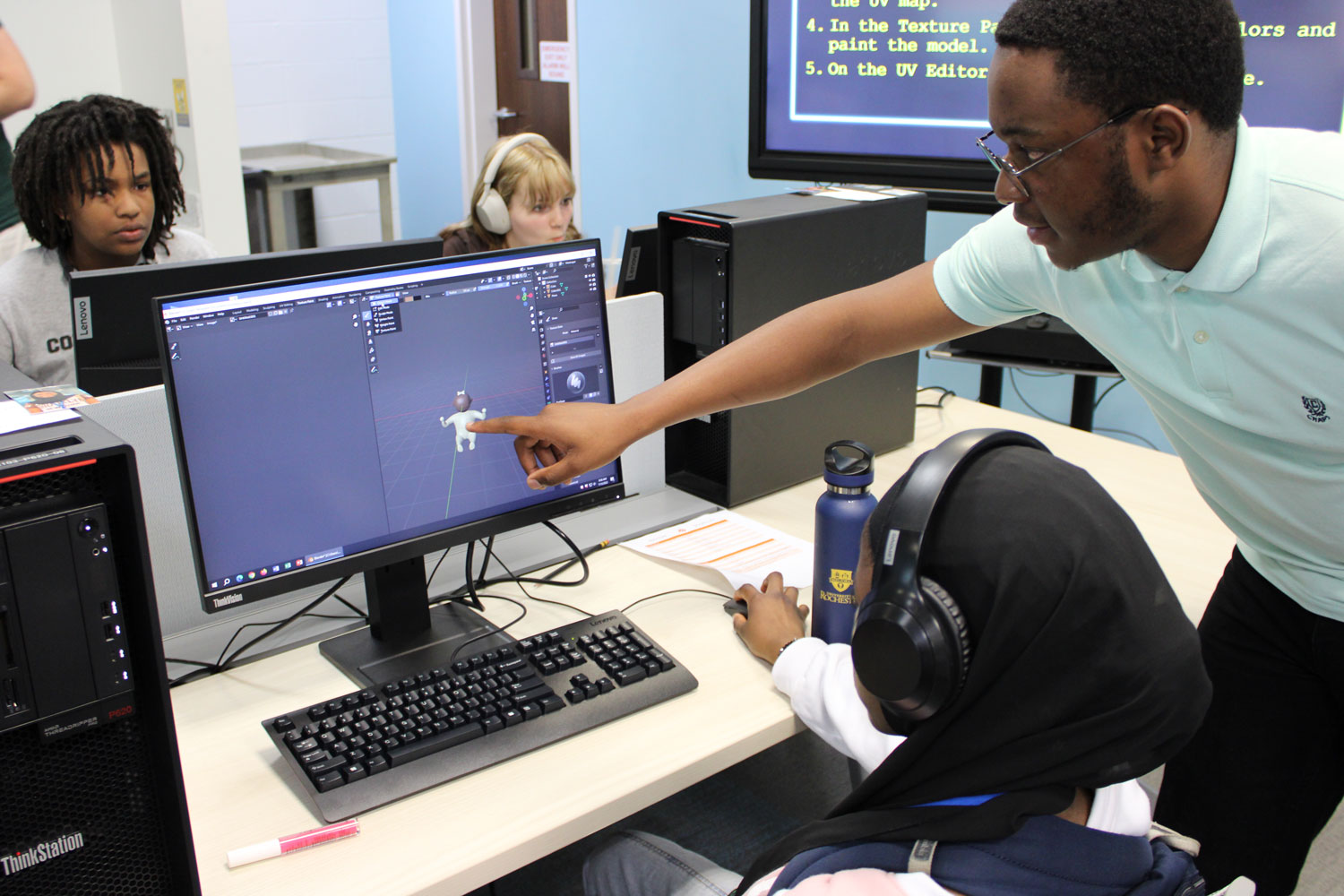 Tamuda points at a 3D model a student created in Blender.