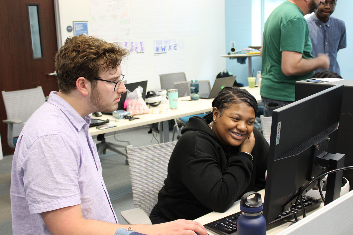 Liam helps a student troubleshoot an issue with the project.