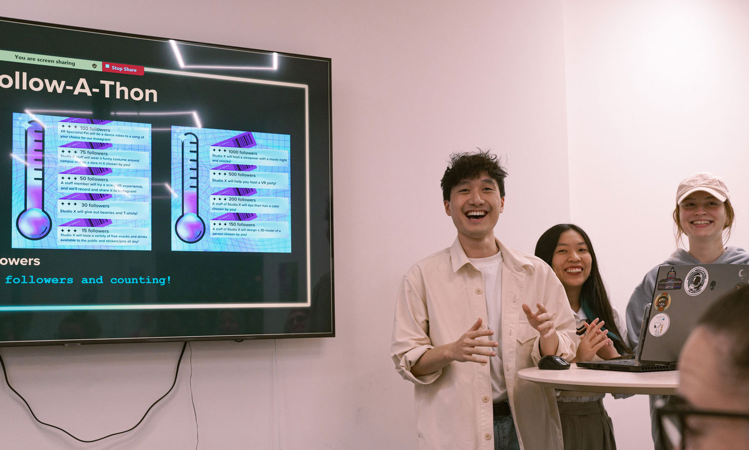 Fin, Sarah, and Liz present on the marketing team's work at the Student Showcase.