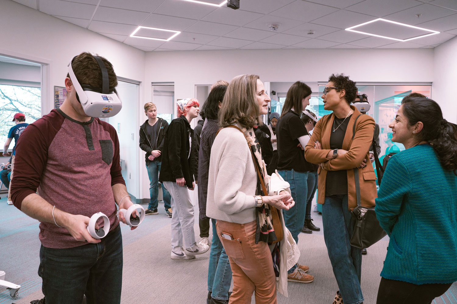 Students and staff try on Meta Quest 2 headsets and talk to each other during the Student Showcase event.