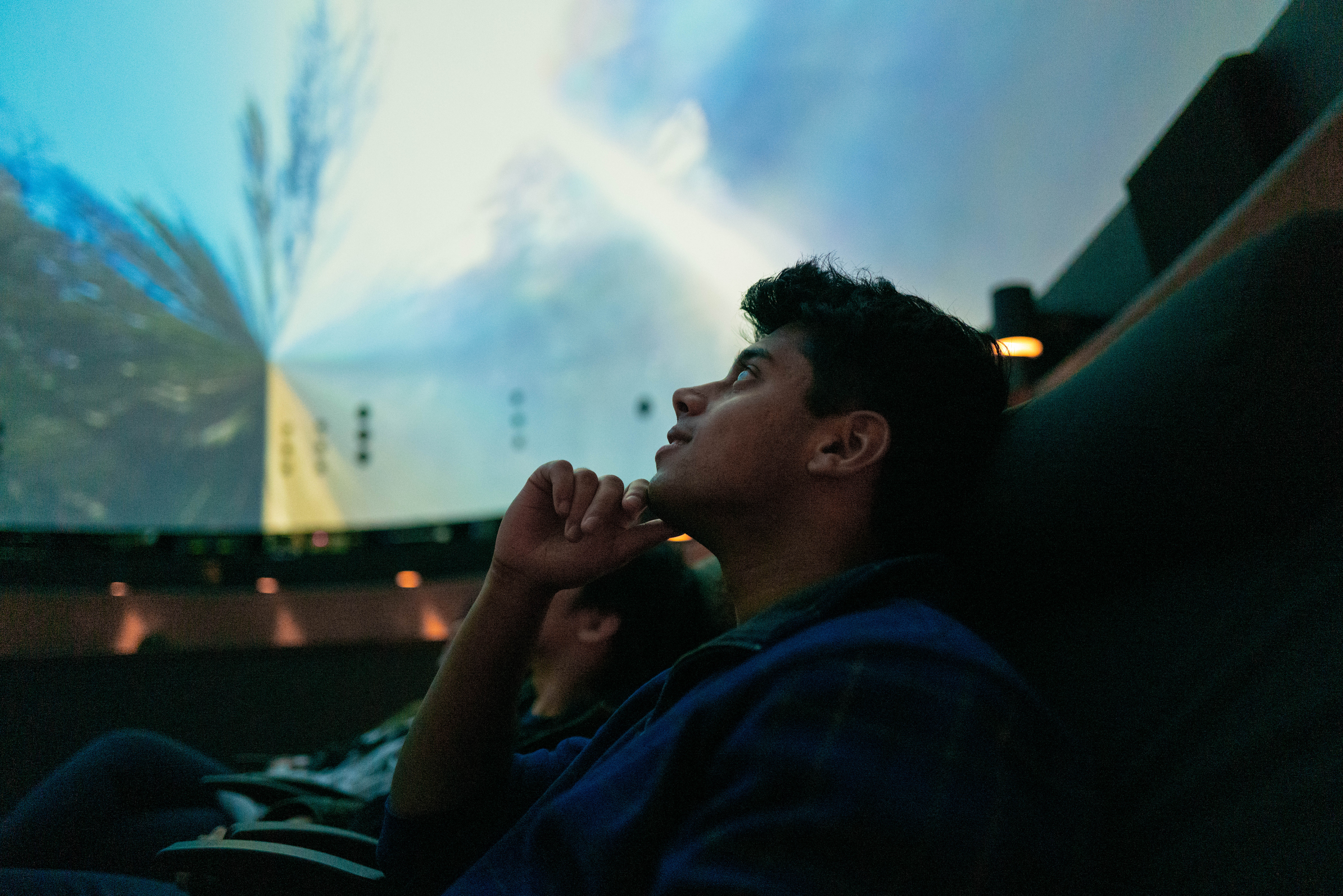 Student looking up at immersive film screen.