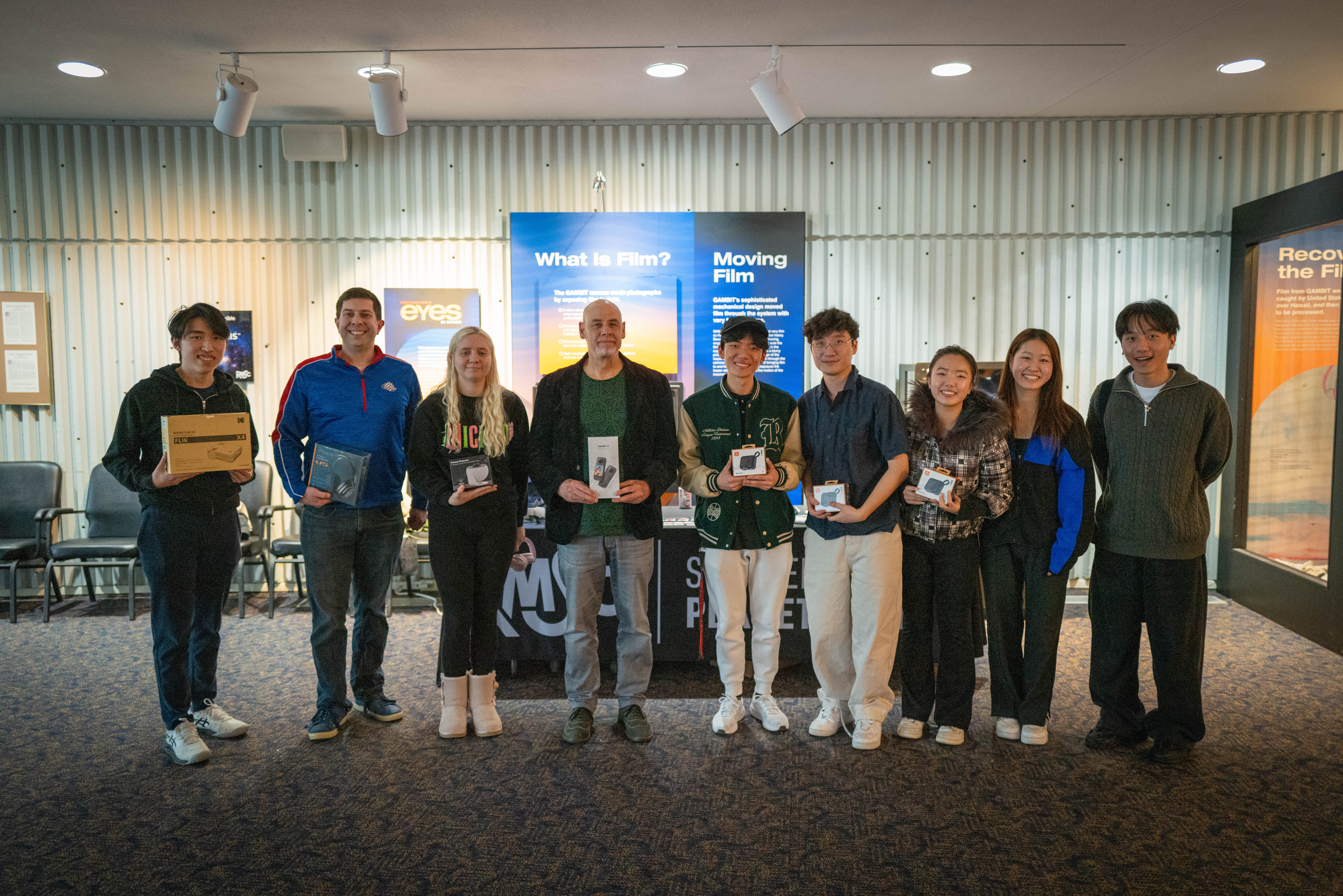 Nine people lined up holding tech prizes at film festival.