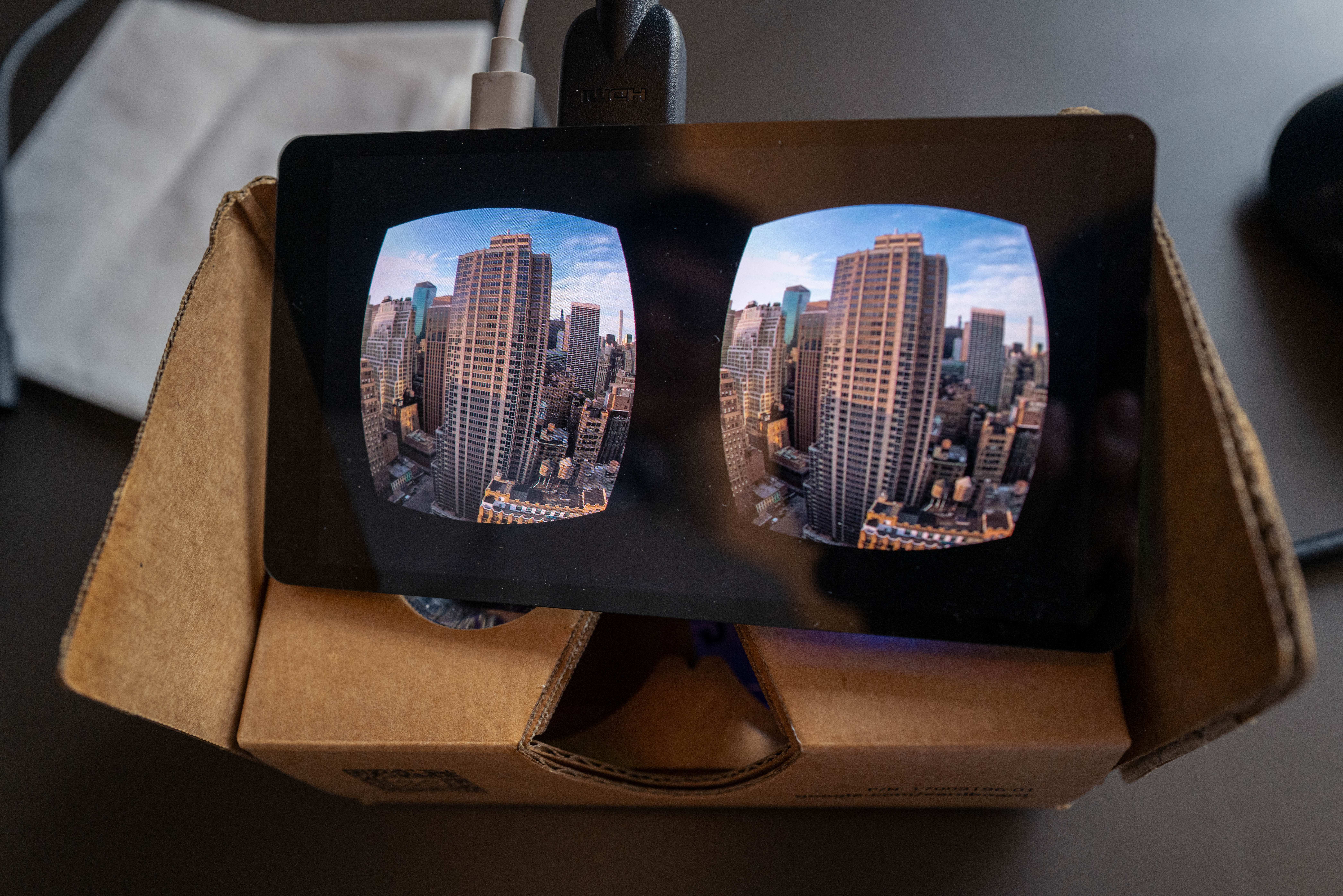 Cardboard VR headset viewing city skyline.